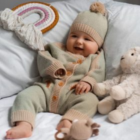 Un bebe sonriente tumbado entre muchos cojines